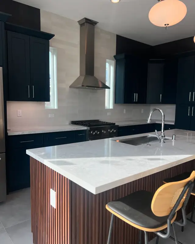 ADU kitchen with navy cabinets and a waterfall island
