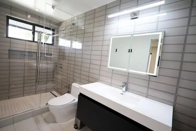 Bathroom with flush tile and a floating vanity